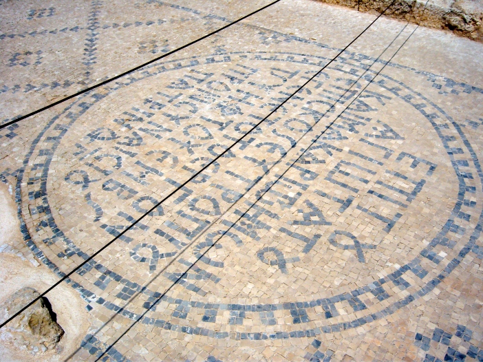 A Greek inscription, in tile mosaic, on the street.